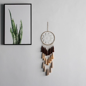 Detail of bohemian dream catcher with white crochet pattern and tiered gradient tassels