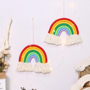 Detail of colorful rainbow cotton woven wall hanging with tassels in a boho nursery setting