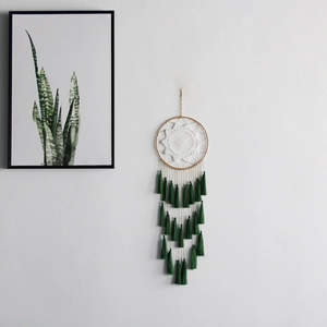 Close-up of bohemian dream catcher with white lace crochet and deep green tassels