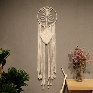 Detail of bohemian macramé wall hanging with intricate geometric weave and cotton fringe