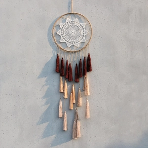 Detail of bohemian dream catcher featuring white crochet star and long silk tassels