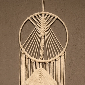 Detailed close-up of handmade bohemian macramé wall hanging with woven fringe