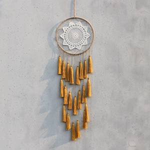 Detail of bohemian dream catcher with white lace sun flower and golden tassels