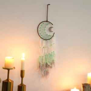 Detail of moon-shaped dreamcatcher with gradient feathers and green bead weaving