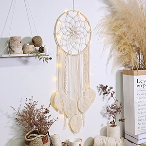Detail of bohemian handmade woven dream catcher with warm LED fairy lights for home decor
