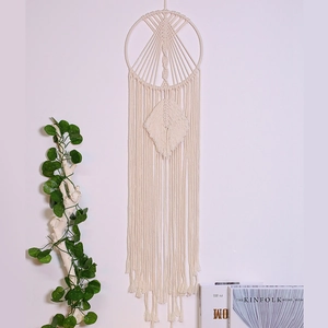 Detailed close-up of bohemian hand-woven cotton macrame wall hanging with leafy patterns