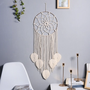 Detailed view of handmade bohemian wall hanging featuring woven leaf tassels and white cotton rope