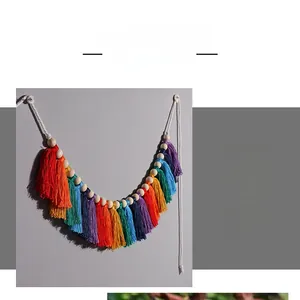 Close-up of rainbow macrame wall hanging with colorful cotton tassels and wooden beads