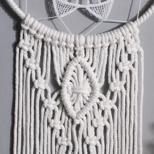 Detailed macro view of hand-woven cotton bohemian dreamcatcher with lace borders