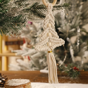 Macro detail of macrame Christmas tree ornament with wooden beads and golden thread