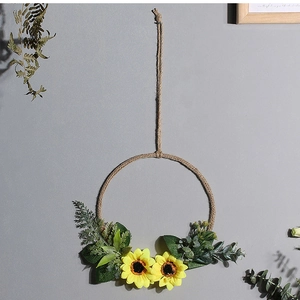 Detail of Nordic artificial sunflower wreath with jute rope loop on a light grey wall