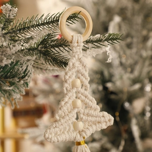Close-up of bohemian macrame Christmas tree hanging with cotton rope and wood beads
