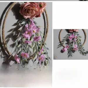 Detail showing artificial pink roses and purple flower vines on a hemp rope ring