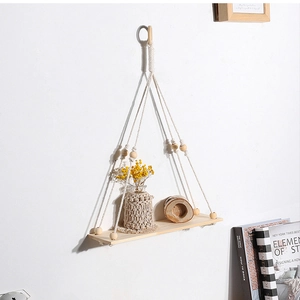 Detail of bohemian wooden wall shelf with woven cotton rope and natural wood beads