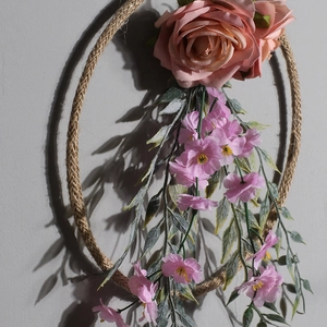 Dettaglio di ghirlanda di rose rosa artificiali fatta a mano con corda di canapa e fiori