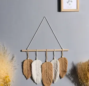 Detailed view of handmade macrame leaf tapestry with wooden beads on a boho wall hanging