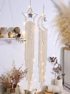 Detailed close-up of handmade bohemian macrame star and moon wall hanging with fringe