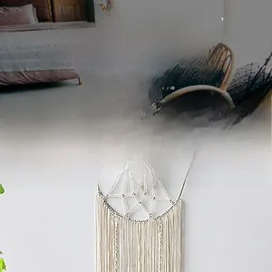 Detail of handwoven white cotton wall hanging with leaf bohemian fringe decor
