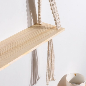 Detail of hand-woven cotton rope texture and natural wood grain on boho hanging shelf
