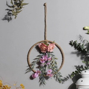 Dettaglio di rose rosa e fiori viola su una ghirlanda rustica in corda di canapa decor