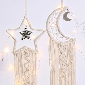Detailed macro view of bohemian handwoven cotton star and moon dreamcatcher wall hangings