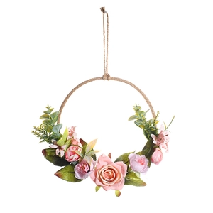 Dettaglio di rose rosa e foglie di eucalipto su una ghirlanda floreale di corda di canapa