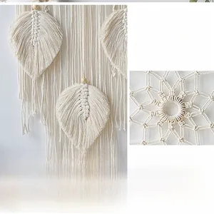 Close-up of handmade beige macrame wall hanging featuring leaf tassels and wooden beads