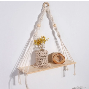 Detail view of Bohemian macrame wall shelf with hand-woven cotton ropes and solid wood board