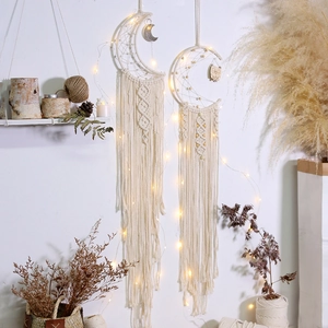 Detail of handmade macrame moon and round dreamcatchers with LED warm lights and tassels