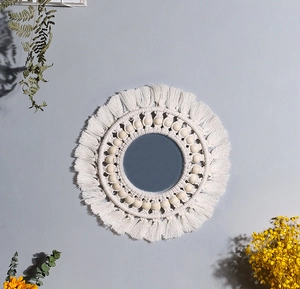 Detailed view of bohemian woven cotton wall mirror with natural wooden beads and fringe