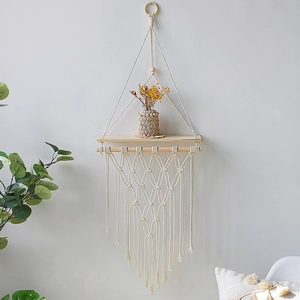 Detailed macro view of bohemian handwoven cotton rope macrame and solid wood wall shelf