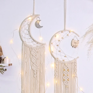 Detail of bohemian moon and owl macrame wall hangings with cotton rope and warm LED lights