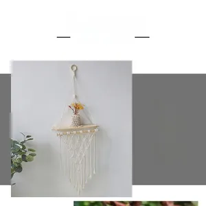 Detail of bohemian hand-woven cotton rope wall shelf with wooden board and tassels