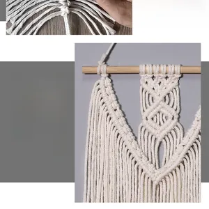 Detail of bohemian hand-woven macrame wall hanging with ivory cotton ropes and wood rod