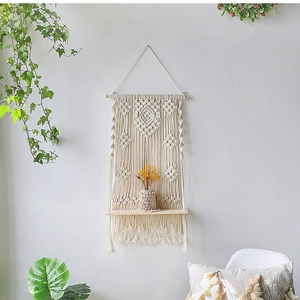 Detail of bohemian handmade woven wall shelf with cream cotton rope and wooden board