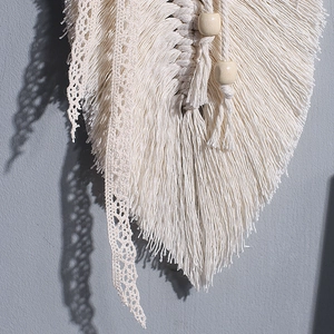 Dettaglio decorazione murale macramé con foglie in corda di cotone e perle in legno