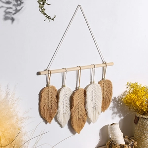 Handmade Bohemian wall hanging with five woven cotton leaves on a natural wood branch