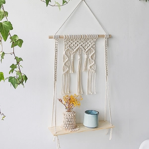 Detail view of handmade macrame floating shelf with woven texture and natural cotton tassels