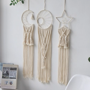 Detail of three-piece bohemian moon and star woven wall hangings with long tassels