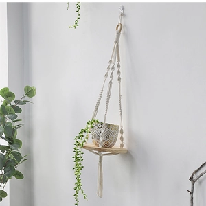 Detail view of macrame plant hanger with wooden shelf and woven cotton rope texture