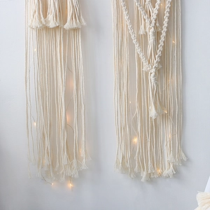Detailed macro view of woven macrame cotton rope and warm LED lights on wall hanging
