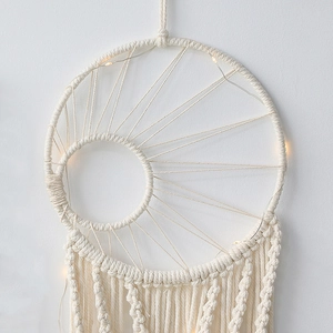 Detailed close-up of bohemian woven moon dreamcatcher with warm LED fairy lights