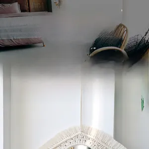 Détail du miroir mural macramé bohème avec franges en coton blanc et tissage délicat