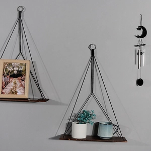 Close-up of wall-mounted wooden floating shelf with black rope and metal ring hanger