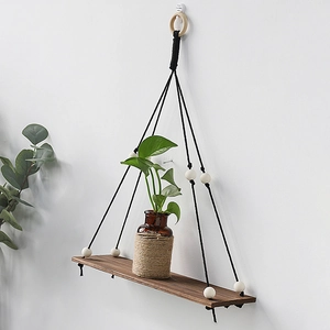 Detail of Nordic wooden hanging shelf with black ropes and white beads decoration
