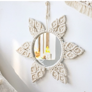 Detail of handmade macramé wall mirror showing intricate white cotton rope textures