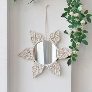 Detail of bohemian handmade woven wall mirror with beige cotton rope sunburst pattern
