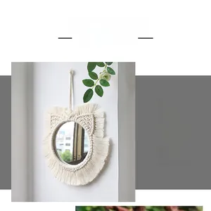 Detailed close-up of handmade macrame cat ear wall mirror with white cotton tassels