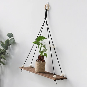 Minimalist hand-woven wooden swing shelf with dark wood board and black hanging ropes