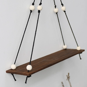 Handwoven macrame wall hanging shelf with dark wood board and decorative white beads
